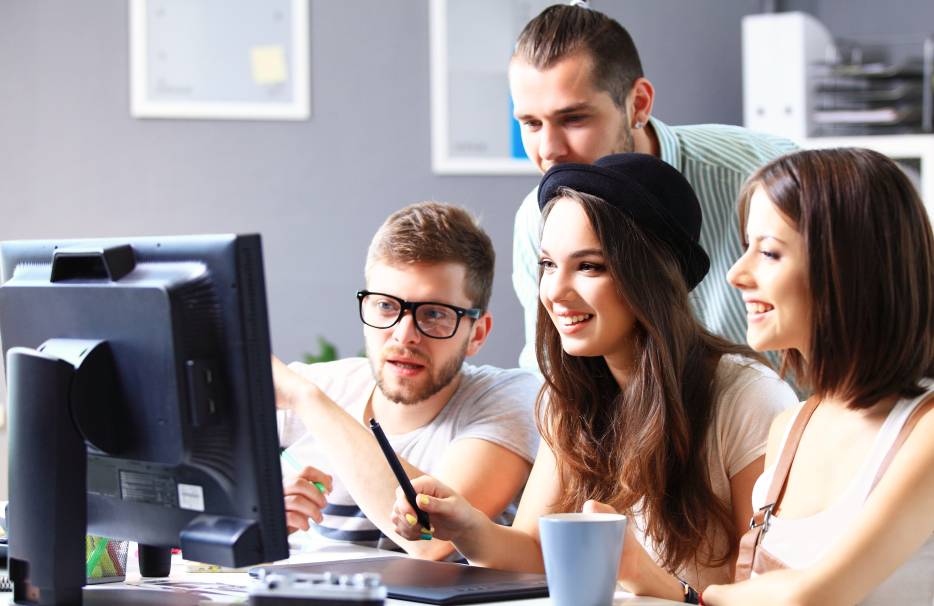 Three interns being taught by an employee